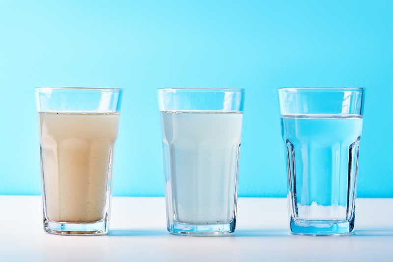 Water filters. Concept of three glasses on a white blue background. Household filtration system.